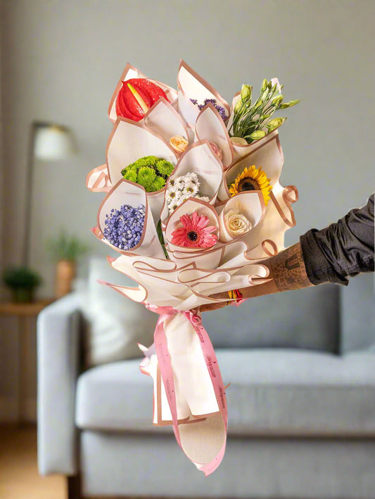 Bouquet of flowers held by a hand on a white background